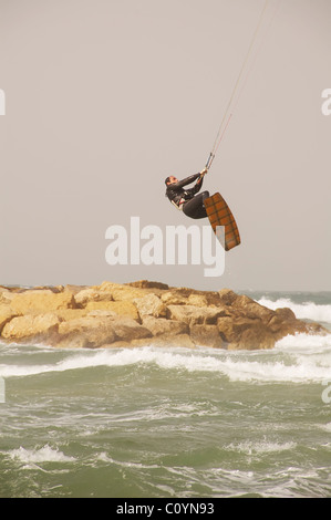 Kite surfer saltando su una grigia giornata invernale Foto Stock