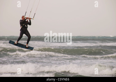 Kite surfer saltando su una grigia giornata invernale Foto Stock