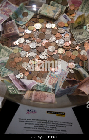Box collection / raccolta valuta estera / piccola modifica / denaro / Contanti / monete per carità presso l'aeroporto di Heathrow di Londra. Regno Unito. Foto Stock