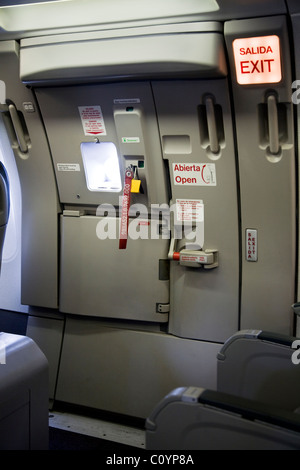 Fila di uscita e uscita di emergenza porta a scendere (e di evacuazione di emergenza) dalla cabina / fusoliera su un aeromobile Airbus / aeroplano / piano / aereo. Foto Stock