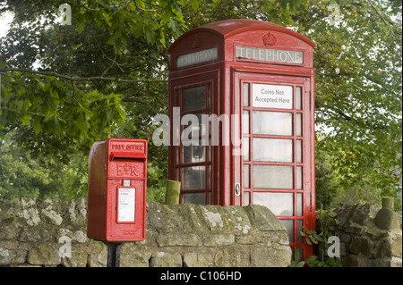 Arredo Urbano - rosso post box & storico iconica K6 telefono scatola da parete stalattite nello scenico villaggio rurale - Leathley, North Yorkshire, Inghilterra, Regno Unito. Foto Stock