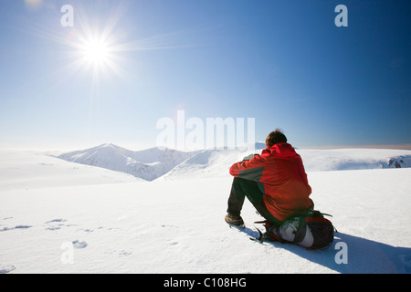 Un alpinista guardando verso gli Angeli picco sulla Lairig Ghru dal vertice del Ben Macdui, sul Cairngorms Foto Stock