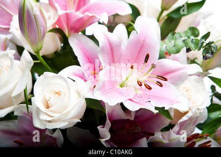 Una sharp,focalizzata, vicino la foto di un mazzo di fiori, compresi bellissimi rose bianche, baby gigli rosa e foglie verdi. Foto Stock