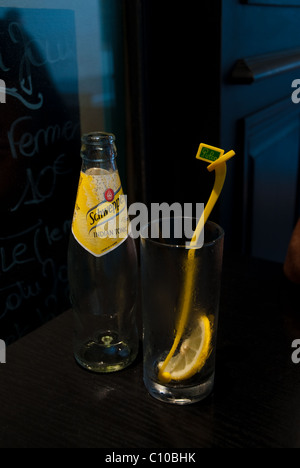 Schweppes Indian tonic bottiglia con vetro, limone e bacchetta di agitazione Foto Stock