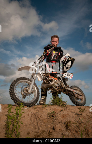 Un bambino di sei anni ragazzo con la sua moto motocross Foto Stock