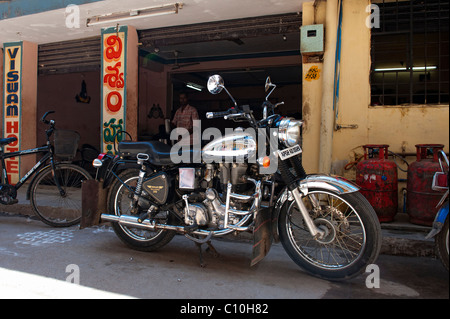 Chrome Royal Enfield 350 bullet motocicletta. Al di fuori di un indiano ristorante Tiffin shop. Puttaparthi, Andhra Pradesh, India Foto Stock