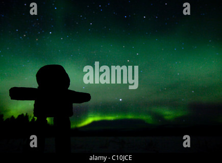 Silhouette di Inuit uomo di pietra, inukshuk, inuksuk, pietra landmark o cairn, polare settentrionale luci, Aurora Boreale, verde Foto Stock