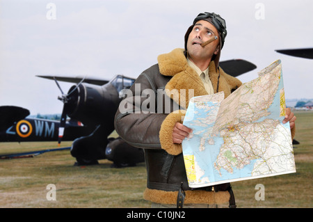 Durante la Seconda Guerra Mondiale pilota da caccia con mappa guardando verso il cielo Foto Stock