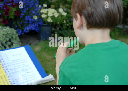 Giovane ragazzo giocando recorder Foto Stock