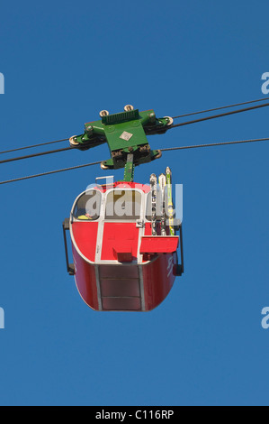 Cabina rosso del Kampenwandbahn funivia con gli sci sul lato esterno della cabina, salire la montagna, Chiemgau, Bavaria Foto Stock