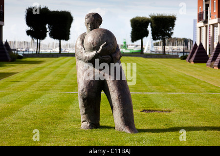 'Man e ball' scultura di Giles Penny, davanti al palazzo di Vulcan, Gunwharf Quays, Portsmouth. Foto Stock