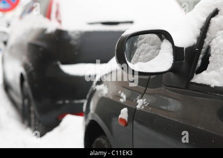 Lato sinistro specchio di una coperta di neve nero auto, inverno, Germania Foto Stock