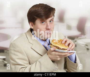 Divertente giovane caucasico mangia una carta igienica. Si è dimenticato di  acquistare cibo nel panico coronavirus. Studio Foto stock - Alamy