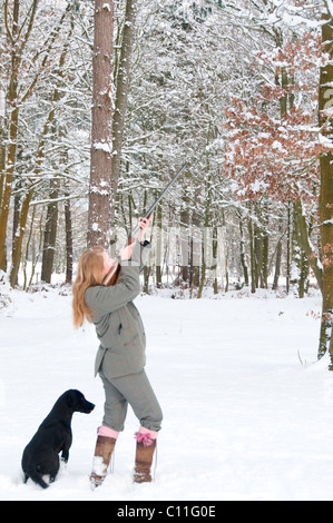 Pistola femmina con labrador fuori su un germoglio nevoso Foto Stock