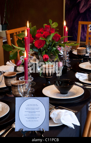 Close-up di un tavolo da pranzo insieme per un San Valentino la cena con un menu in primo piano Foto Stock