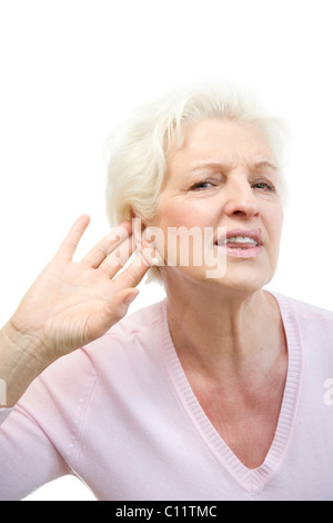 Vecchia donna non riesce a sentire qualcosa, mette mano dietro il suo orecchio Foto Stock