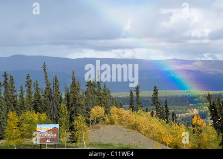 Rainbow, estate indiana, gli alberi in autunno colori, Whitehorse accogliente segno, Two Mile Hill, Whitehorse, capitale di Yukon Territory Foto Stock