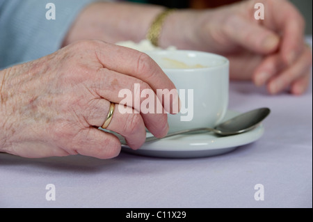 Il vecchio donna di mano che regge una tazza di caffè, Germania, Europa Foto Stock