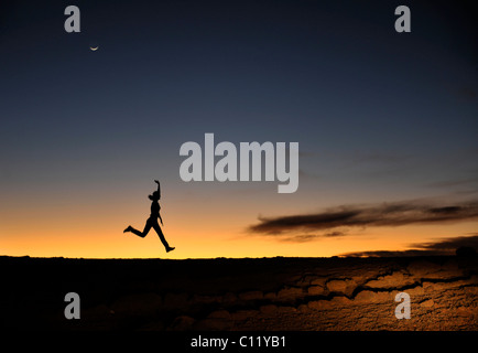 Silhouette di donna sulla montagna all'alba. Sagome di persone contro il cielo di notte. Dopo un declino. Foto Stock