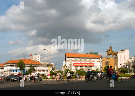 Le persone sono la guida di motocicli passato l'oro Tran Nguyen Han monumento nel traffico pesante a Saigon (Ho Chi Minh City) Vietnam. Foto Stock