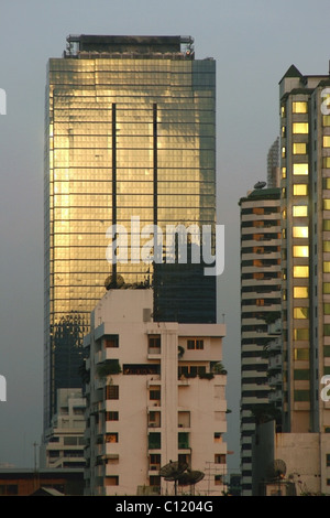 La mattina presto il sole è riflesso di un alto e moderno edificio di vetro a Bangkok, in Thailandia. Foto Stock