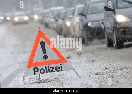 Il triangolo di avvertenza della polizia sulla coperta di neve strada di fronte ad un ingorgo, Stoccarda, Baden-Wuerttemberg, Germania, Europa Foto Stock