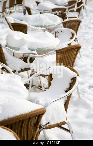 Coperte di neve sedie in una street cafe in inverno Foto Stock