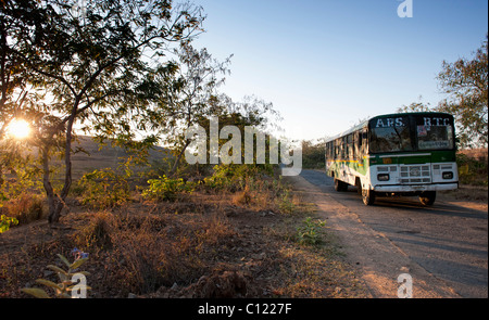 Indian bus / pullman in viaggio la mattina presto a sunrise in campagna. Andhra Pradesh, India Foto Stock