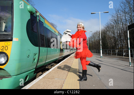 Tina mulini da Brighton vestito in un rosso tutu dando via libera Libri sui treni per Londra come parte del mondo libro notte Foto Stock
