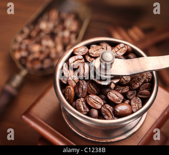 Caffè torrefatto in grani macinati in un macinino da caffè. Foto Stock