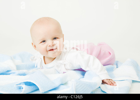 Sorridente bambino giacente su un asciugamano blu. Studio fotografico Foto Stock