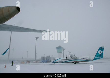 Neve, in inverno, roll out, Air Dolomiti aereo, torre di controllo, east grembiule, Aeroporto di Monaco di Baviera, MUC, Baviera, Germania, Europa Foto Stock