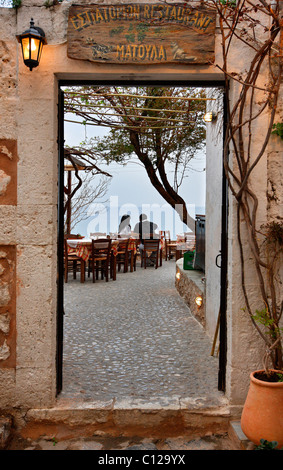 Un giovane godendo la loro cena in uno dei ristoranti pittoreschi del 'castletown' di Monemvasia, Laconia, Grecia Foto Stock