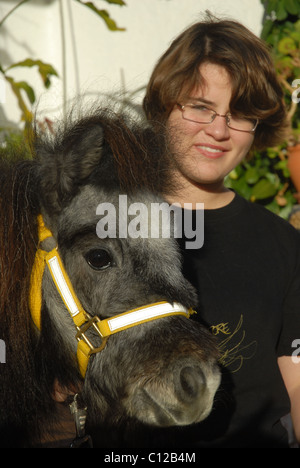 Ragazza (età 12) con pet Falabella cavalli in miniatura Foto Stock