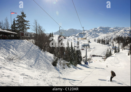 Gli sciatori su una seggiovia a Vogel centro sci di fondo nel Parco Nazionale del Triglav di Slovenia montagne di montaggio Foto Stock