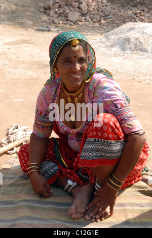 Ritratto di signora indiana squatting/seduto su una coperta nel deserto di Rajasthani Foto Stock