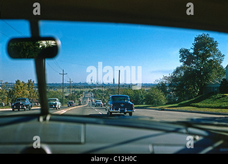 Passeggeri-eye vista attraverso il parabrezza di traffico voce in autostrada in New Jersey verso New York City, c. 1956 Foto Stock