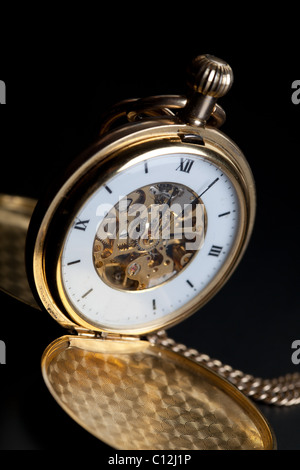 Foto di aperto vecchio vintage orologio da tasca sullo sfondo nero Foto Stock