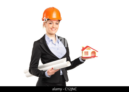 Un sorridente forewoman tenendo un modello di casa e blueprint Foto Stock