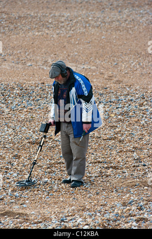 Un uomo su una spiaggia con un rivelatore di metalli Foto Stock