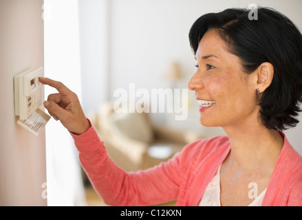 Stati Uniti d'America, New Jersey, Jersey City, donna matura la regolazione temperatura ambiente Foto Stock