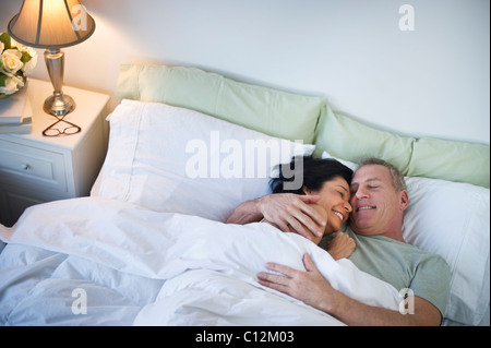 Stati Uniti d'America, New Jersey, Jersey City, felice coppia matura la posa a letto Foto Stock