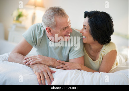Stati Uniti d'America, New Jersey, Jersey City, felice coppia matura la posa a letto Foto Stock