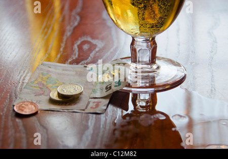 Regno Unito, Bristol, valuta britannica e la birra sul tavolo Foto Stock