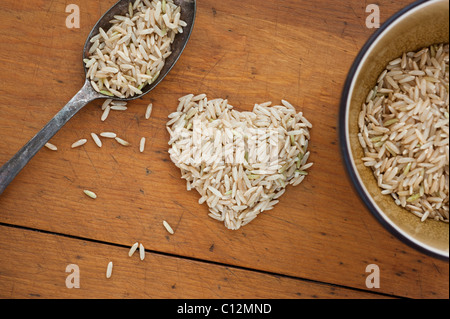 A forma di cuore il riso con il cucchiaio e ciotola Foto Stock