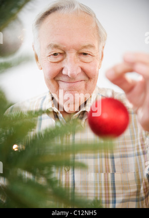 Stati Uniti d'America, New Jersey, Jersey City, ritratto di uomo anziano decorare albero di Natale Foto Stock