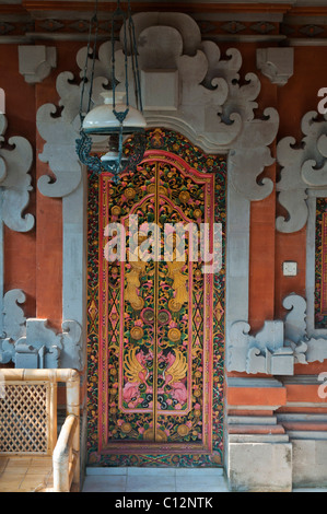 Il tradizionale design Balinese scolpiti porte doppie con olandese antico lampadario Foto Stock