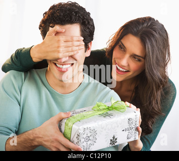 Stati Uniti d'America, New Jersey, Jersey City, giovane donna dando il suo fidanzato presente mentre copre i suoi occhi Foto Stock