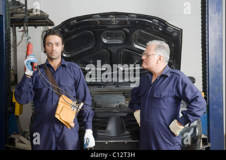 Auto meccanico con un apprendista in un garage Foto Stock