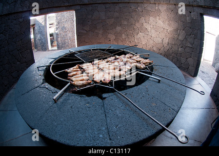 Essendo il pollo cotto sulla griglia sopra il vulcano Lanzarote Foto Stock